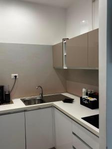 a kitchen with white cabinets and a sink at Matera Central Nest in Matera +6 photos