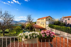 a balcony with flowers inpots on a fence at Maison Vico94 in Vico Equense