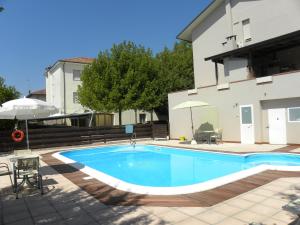 a swimming pool in front of a building at Hotel Riziana in Cervia