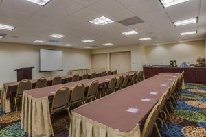 a conference room with tables and chairs and a screen at Holiday Inn Express & Suites Orlando International Airport by IHG in Orlando