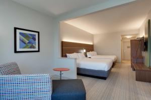 a hotel room with a bed and a couch at Holiday Inn Express & Suites Orlando International Airport by IHG in Orlando +52 photos