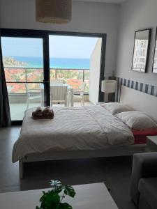 a bedroom with a bed and a large window at Caesar Blue Studio Sea View Apartment in Boghaz +29 photos