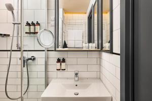 a white bathroom with a sink and a mirror at voco Budapest D8 by IHG in Budapest +154 photos