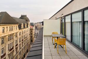 a balcony with a table and chairs on a building at voco Budapest D8 by IHG in Budapest