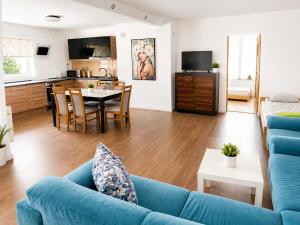 a living room with a blue couch and a table at Pokoje nad Welem Lidzbark in Lidzbark