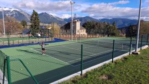 a person is playing tennis on a tennis court at Cozy high-altitude apartment in Font-Romeu-Odeillo-Via