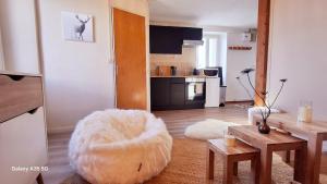 a living room with a large white ottoman and a kitchen at Cozy high-altitude apartment in Font-Romeu-Odeillo-Via