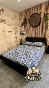 a bedroom with a bed with a poster on the wall at Nos studios au centre ville à Dole in Dole