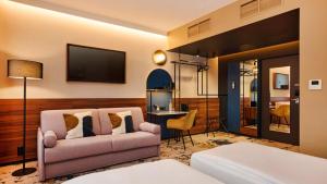 a living room with a couch and a television at voco Budapest D8 by IHG in Budapest