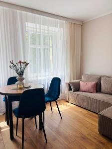 a living room with a table and chairs and a couch at Sowia Przystań in Nowa Ruda