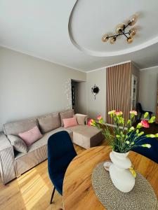 a living room with a couch and a table with flowers at Sowia Przystań in Nowa Ruda