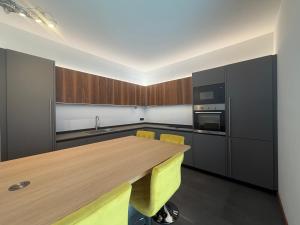 a kitchen with a wooden table and yellow chairs at Prestigiosa vista lago in Como