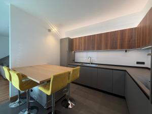 a kitchen with a wooden table and yellow chairs at Prestigiosa vista lago in Como