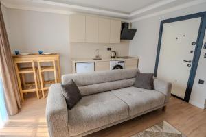 a living room with a couch and a kitchen at Royal Batın Apart Otel in Trabzon