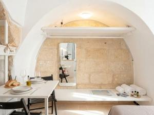 a dining room with a white table and a stone wall at Chiantera in Polignano a Mare +56 photos