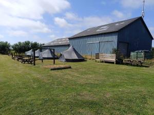 a group of tents in front of a barn at Frifelt Kro Almost Glamping telt in Frifelt