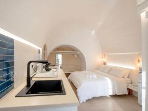 a kitchen with a sink and a bed in a room at Chiantera in Polignano a Mare
