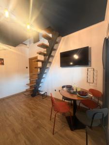 a dining room with a table and a spiral staircase at Tiny Jazz in Gărâna