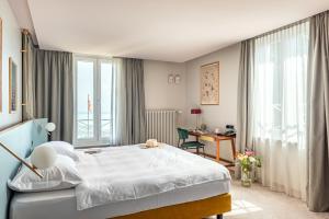 a bedroom with a bed and a desk and window at Hotel du Léman - Jongny in Vevey +111 photos