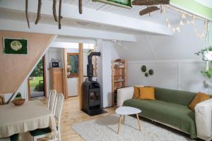 a living room with a green couch and a wood stove at MOHA guesthouse in Szokolya