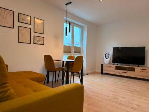 ein Wohnzimmer mit Sofa, Tisch und Fernseher in der Unterkunft CUTE FLAT centrum in Suwałki