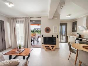 a living room with a television and a table at euphoria villas - Gaia & Aura in Agios Nikitas
