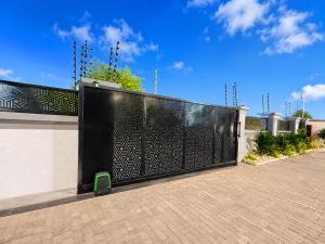 a black fence with a black gate in front of a building at Naso Luxe Homes in Sakumona