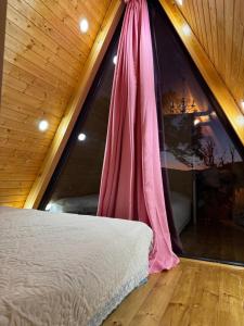 a bed in a room with a large window at Tlughi cottage in Obcha