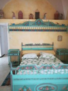 a bedroom with a blue bed and two tables at Villa De la mer in Rafrāf