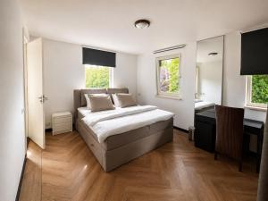 a bedroom with a bed and a desk in it at La Belle Heure B&B - formerly Huis van Steen - in Lelystad