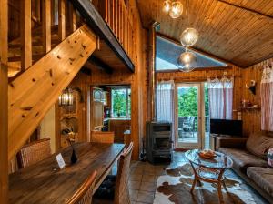 a living room with wooden walls and a wooden table at Haus Waldblick in Extertal