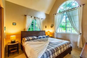 a bedroom with a bed and two windows at Hispaniola Residential - Villas & Apartments! in Sosúa