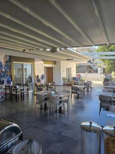an empty restaurant with tables and chairs and tablesearcher at Vila REJANA in Ksamil