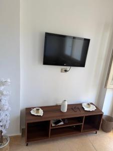 a flat screen tv hanging on a white wall at Ghazala valley ground floor in El Alamein