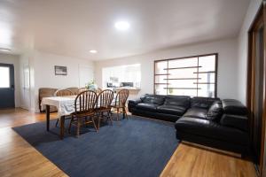 a living room with a black leather couch and a table and chairs at Private Heated Pool House with Sauna CL in Crystal Lake