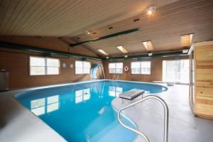 a large swimming pool in a room with wooden walls at Private Heated Pool House with Sauna CL in Crystal Lake