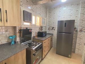 a kitchen with a refrigerator and a stove top oven at Ghazala valley ground floor in El Alamein