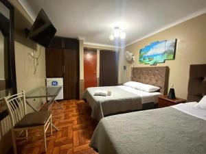 a hotel room with two beds and a desk at Hotel continental in Urbanizacion Buenos Aires