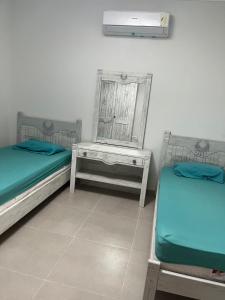 a room with two beds and a mirror and a table at جايا راس الحكمه in Jalāl