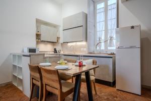 a kitchen with a table with chairs and a refrigerator at Sweet Memories-Gravedona 100m to Lake-Lake Como Escape in Gravedona