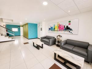 una sala d'attesa con divani e tavoli e un dipinto di Hotel Plazha Express a Tuxtla Gutiérrez