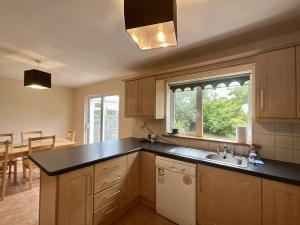 a kitchen with a sink and a window and a table at An Tulan Cleasach Spiddal in Spiddal