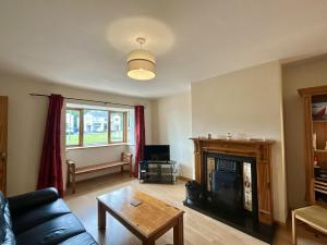 a living room with a couch and a fireplace at An Tulan Cleasach Spiddal in Spiddal