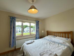 a bedroom with a large bed and a window at An Tulan Cleasach Spiddal in Spiddal