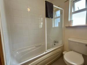 a white bathroom with a tub and a toilet at An Tulan Cleasach Spiddal in Spiddal +13 photos