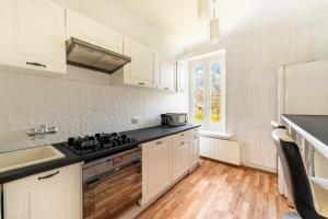 a kitchen with white cabinets and black counter tops at Dwupoziomowy apartament in Dęblin