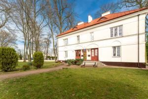 a large white building with a red roof at Dwupoziomowy apartament in Dęblin +6 photos
