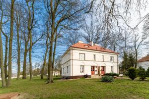 a large white house with a red roof at Dwupoziomowy apartament in Dęblin