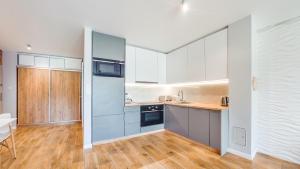 a kitchen with white cabinets and a wooden floor at Jantar Park in Jantar