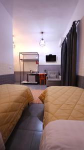 a bedroom with two beds and a living room at Hotel Antigone in Tirana